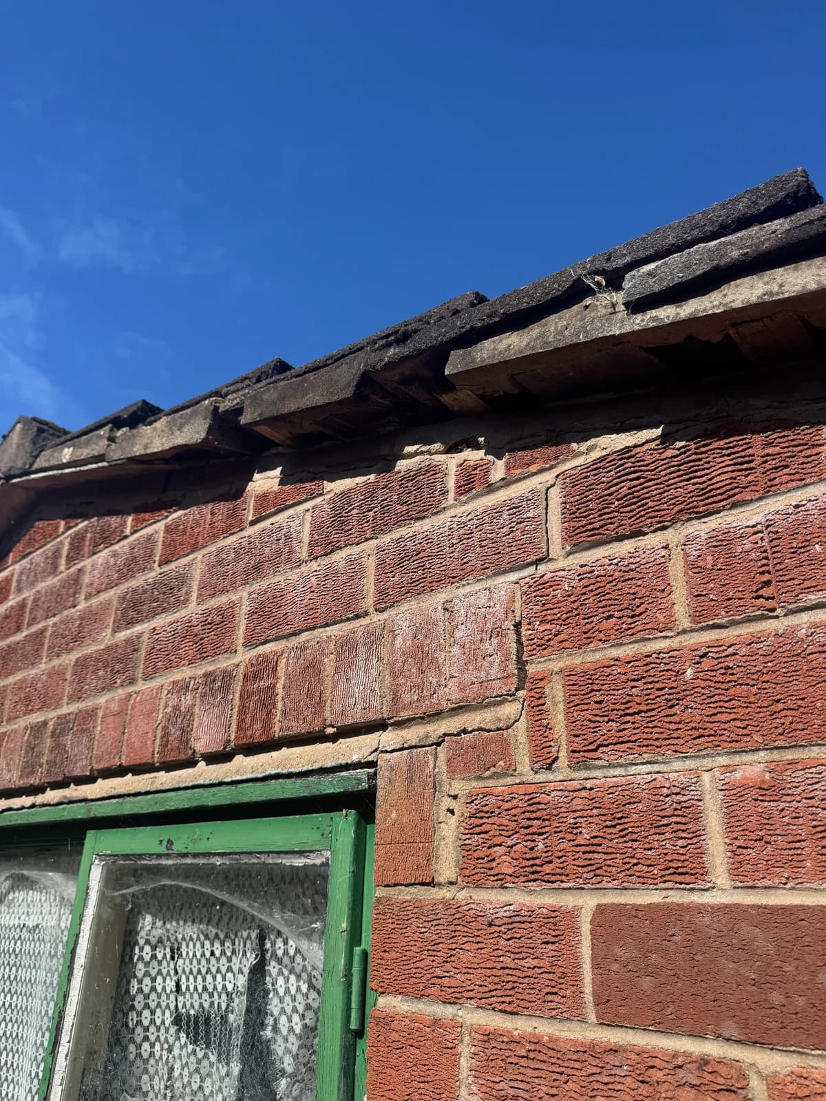 Cracking in masonry above a window opening.